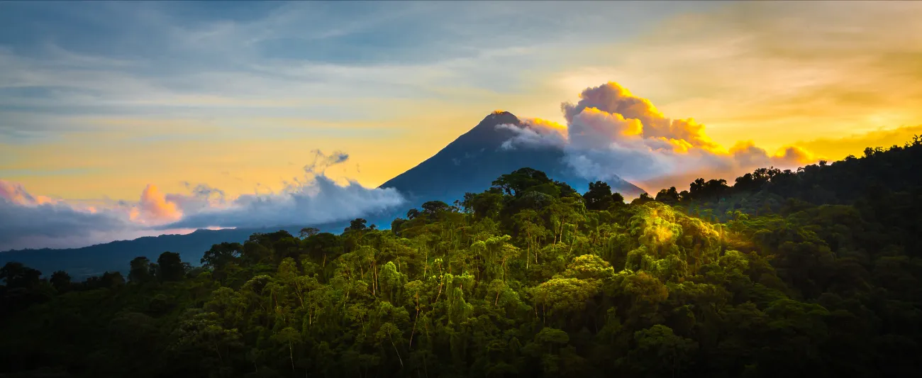 Arenal Volcano at Sunrise...A rare sight at the perfect 15 second window to capture sunrise in all of it's glory. Light glistens off the clouds and the mountain and the jungle