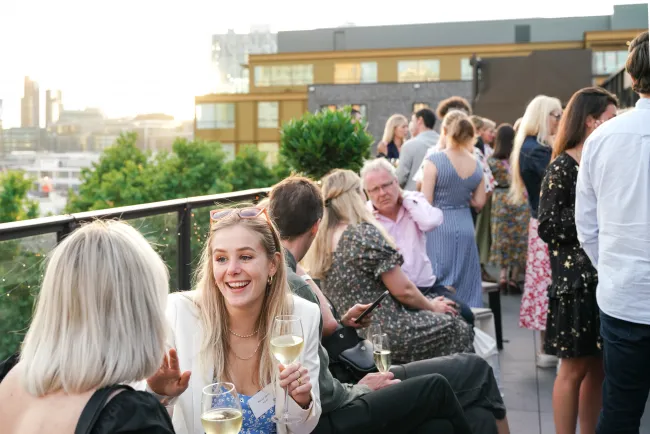 People sharing a drink on a roof terrace in Four's London office